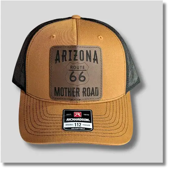 Route 66 trucker hat featuring a vintage-inspired highway patch on a caramel-colored front panel with a curved bill